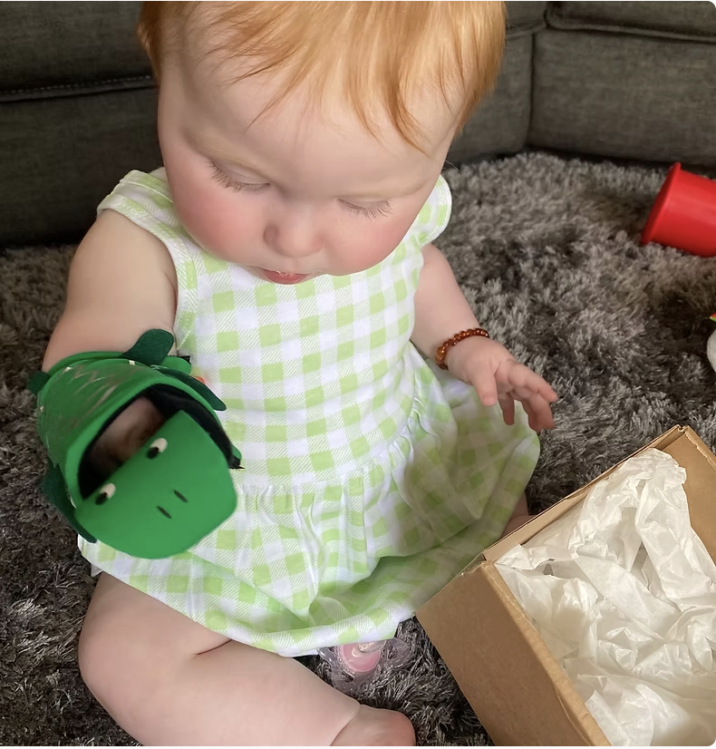 Baby wears green crocodile upper limb prosthetic